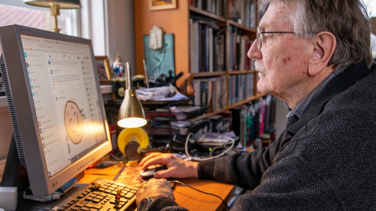 Äldre man sitter vid dator och surfar