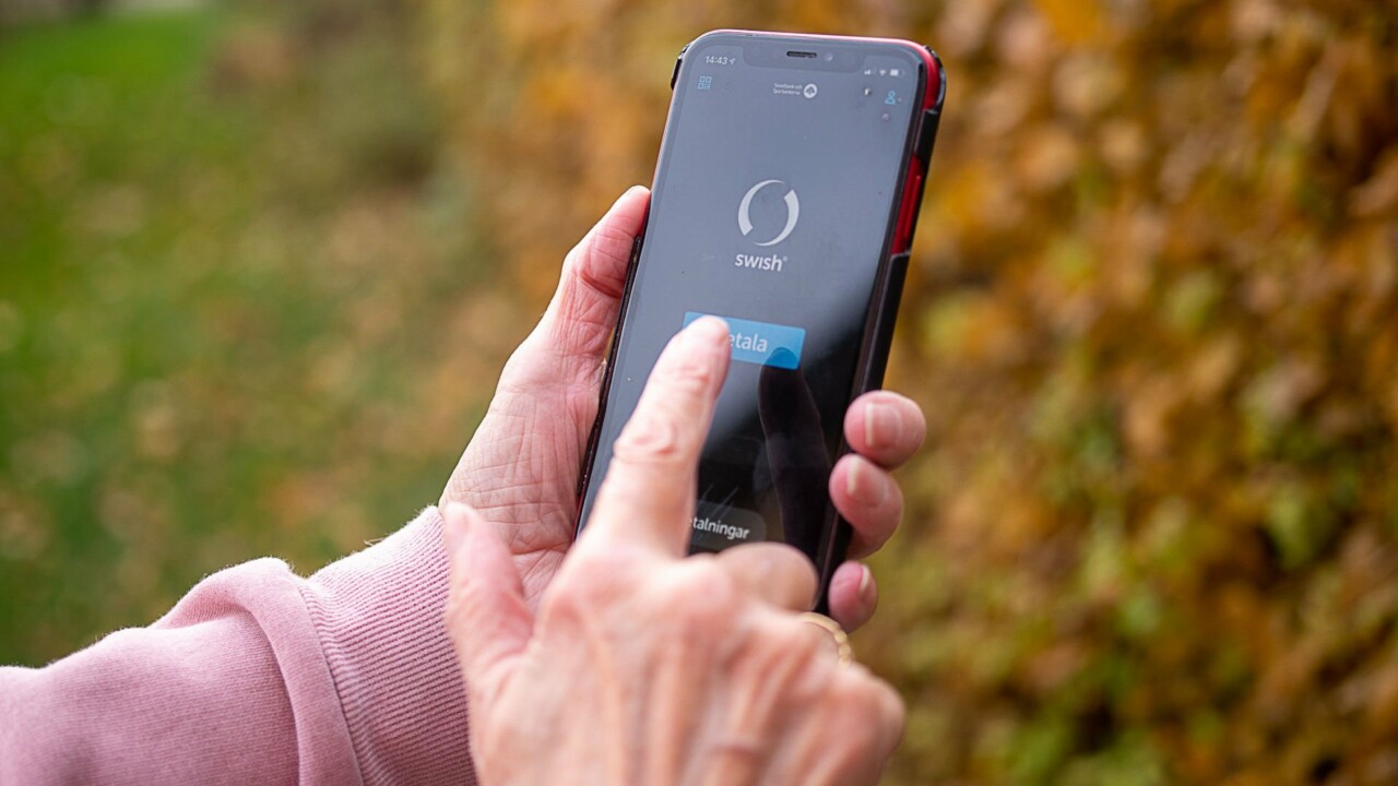Hand som håller en mobil, på skärmen syns bank-id.