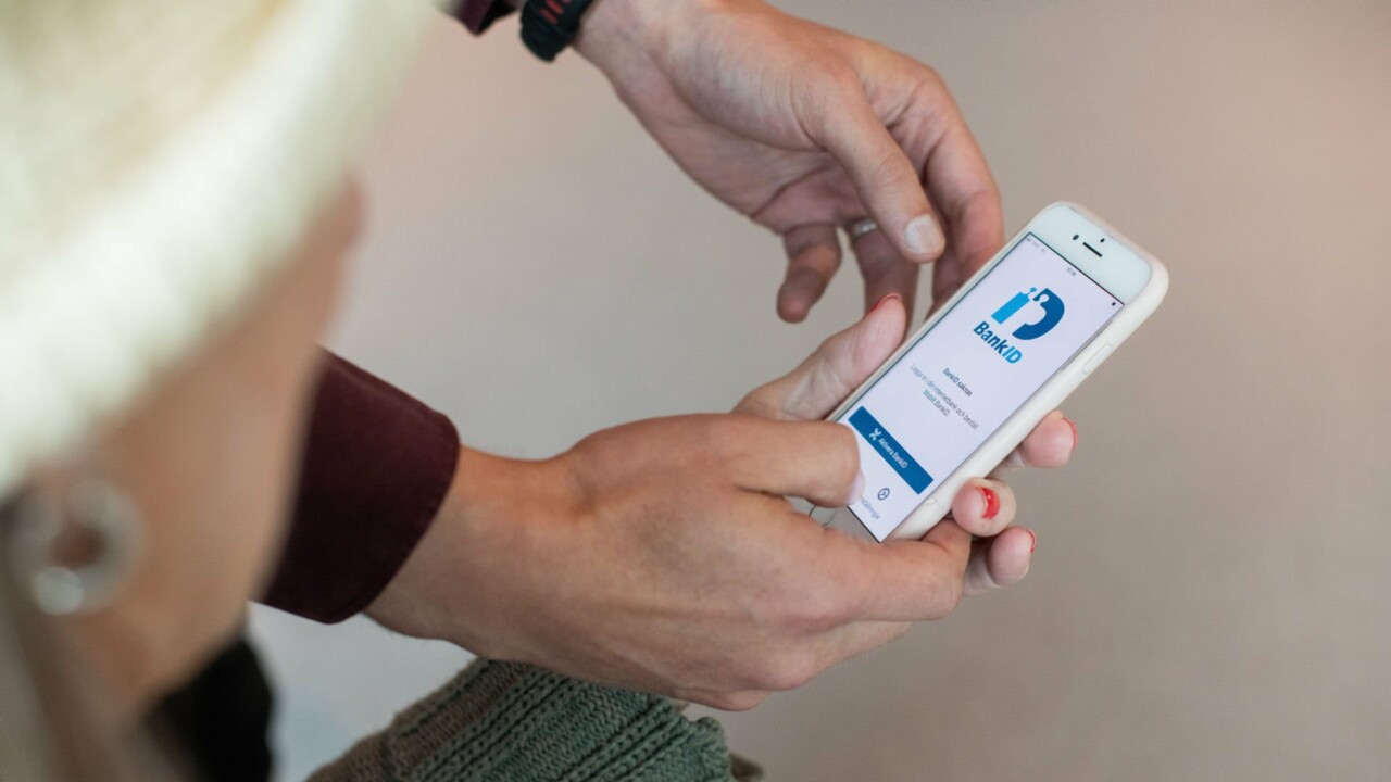 En person hjälper en annan med bank-id på en mobiltelefon.