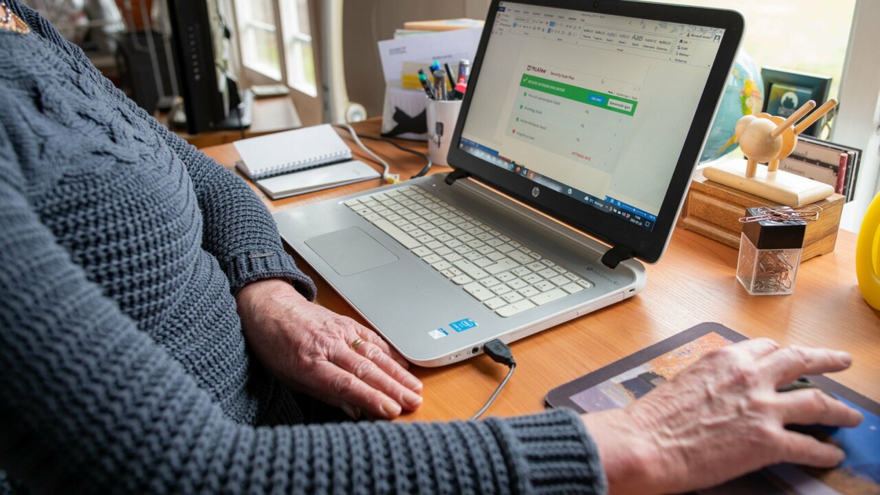 Händer framför datorn, på skärmen syns antivirusprogram