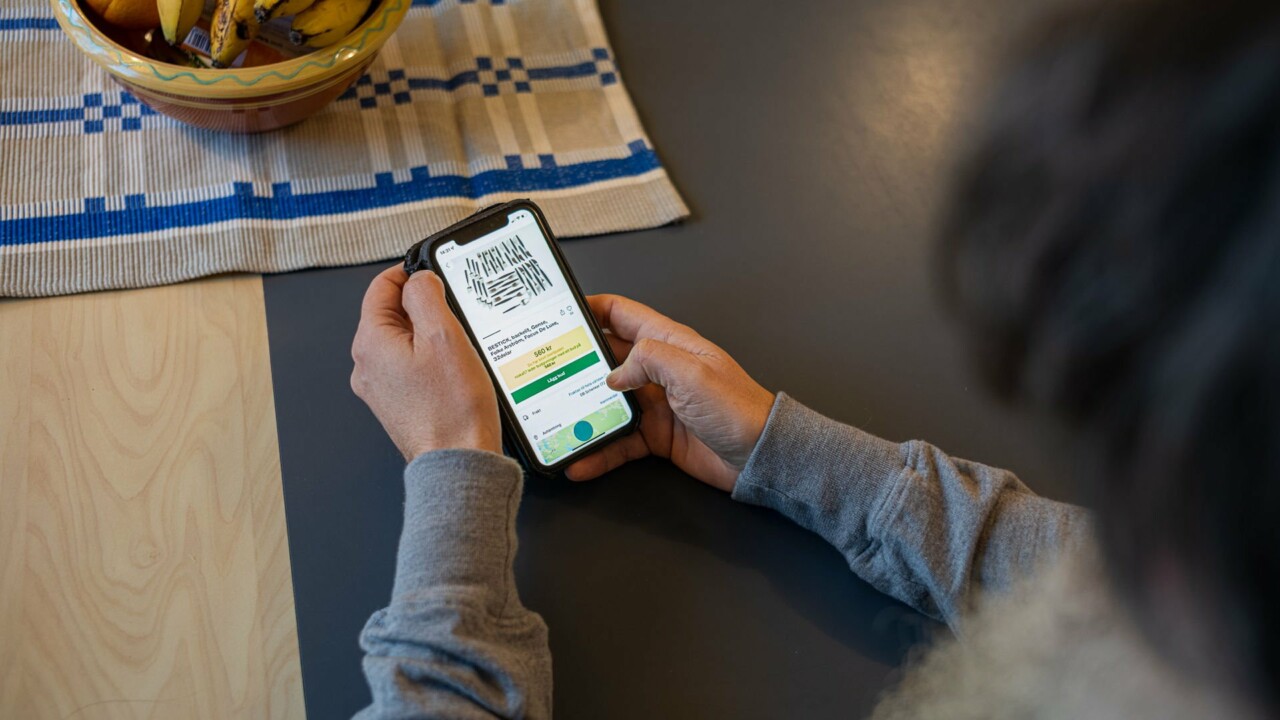 En person som sitter med mobil i händerna, på skärmen syns en begagnatsajt.