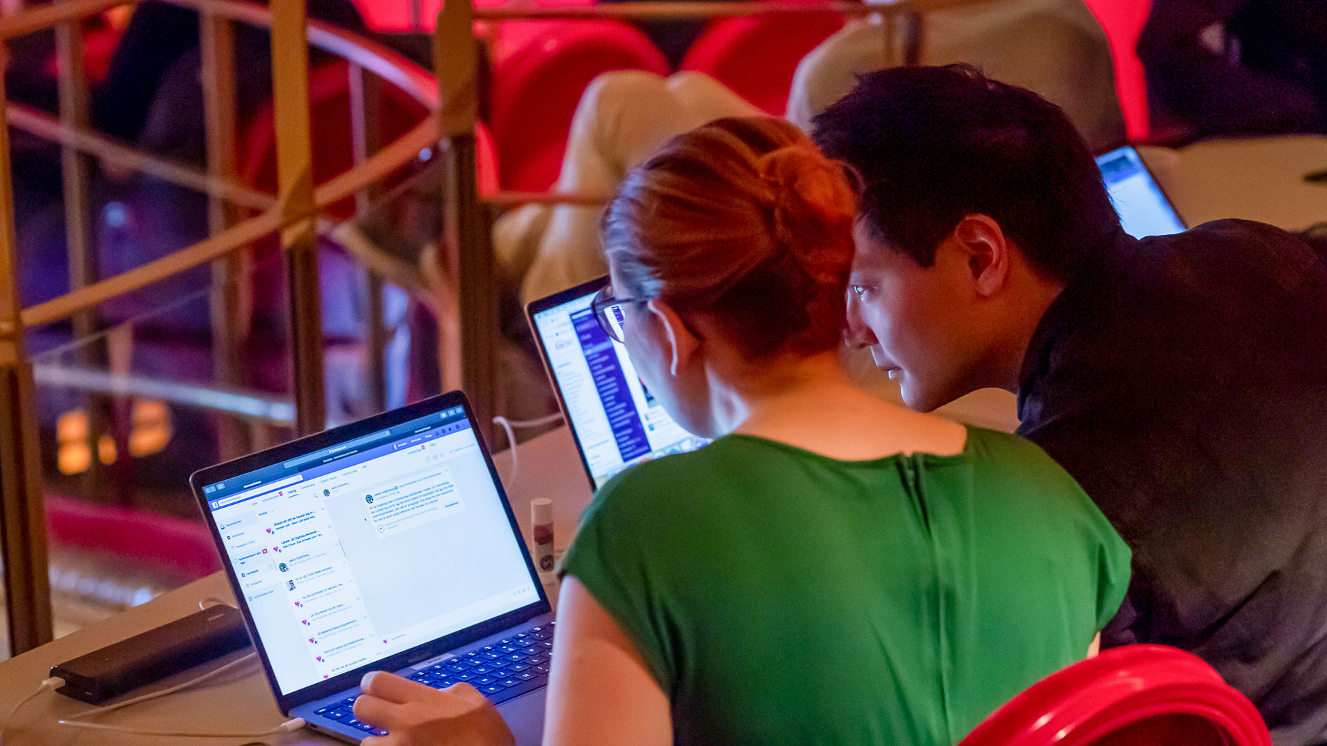 En man och en kvinna sitter tillsammans och tittar på en dator.