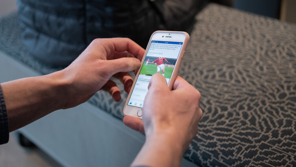 Händer som håller mobiltelefon scrollar på Facebook. Meta samlar in stora mängder data om dig för att använda vid riktad annonsering.