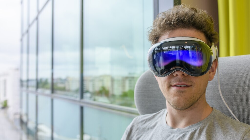 En man som sitter i en stol och bär ett par VR-glasögon.