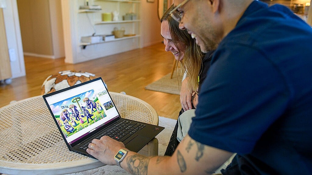 En man och en kvinna tittar på en datorskärm med AI-genererade bilder.